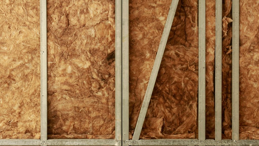 Fiberglass insulation between wall studs.
