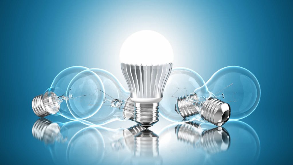 Illuminated LED bulb among incandescent bulbs.