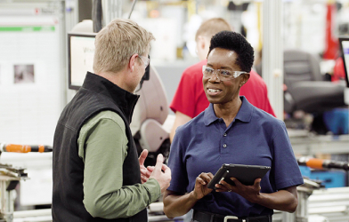 Contractor with tablet talking to business man