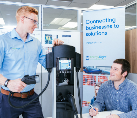 TVA employee demonstrating electric equipment to another man in an office