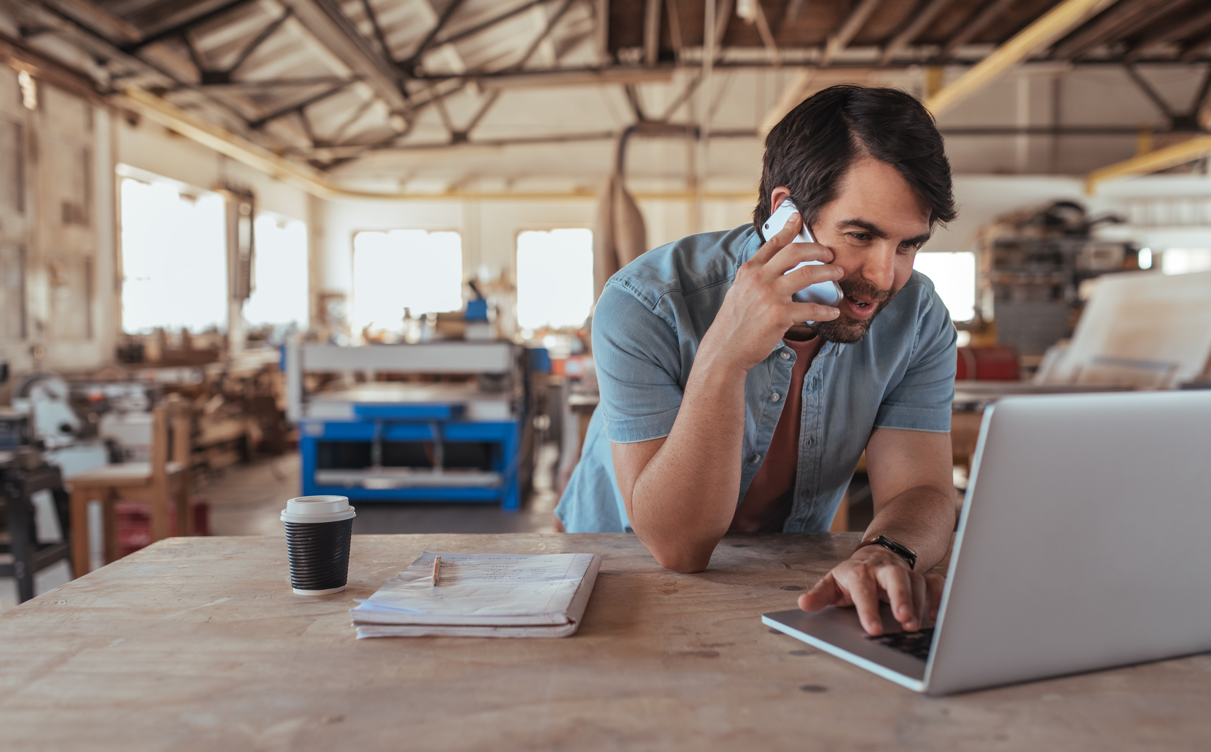 Business owner looking at laptop while talking on the phone