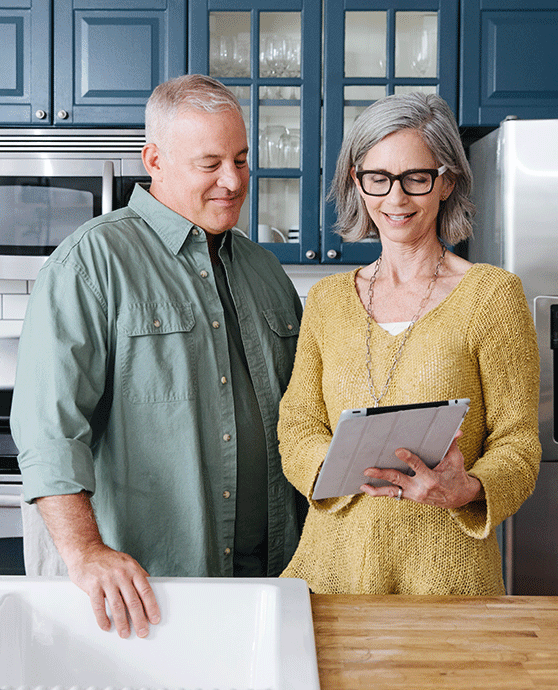 Older couple in kitchen looking at tablet
