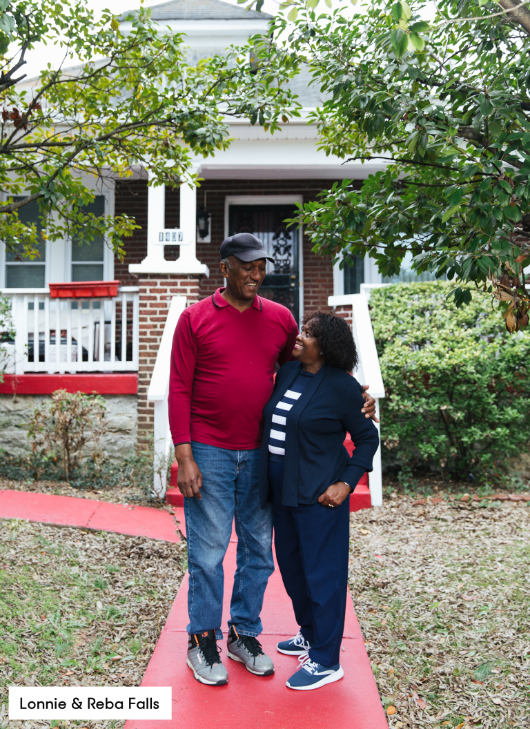 Lonnie and Reba Falls hugging and standing outside in front of house