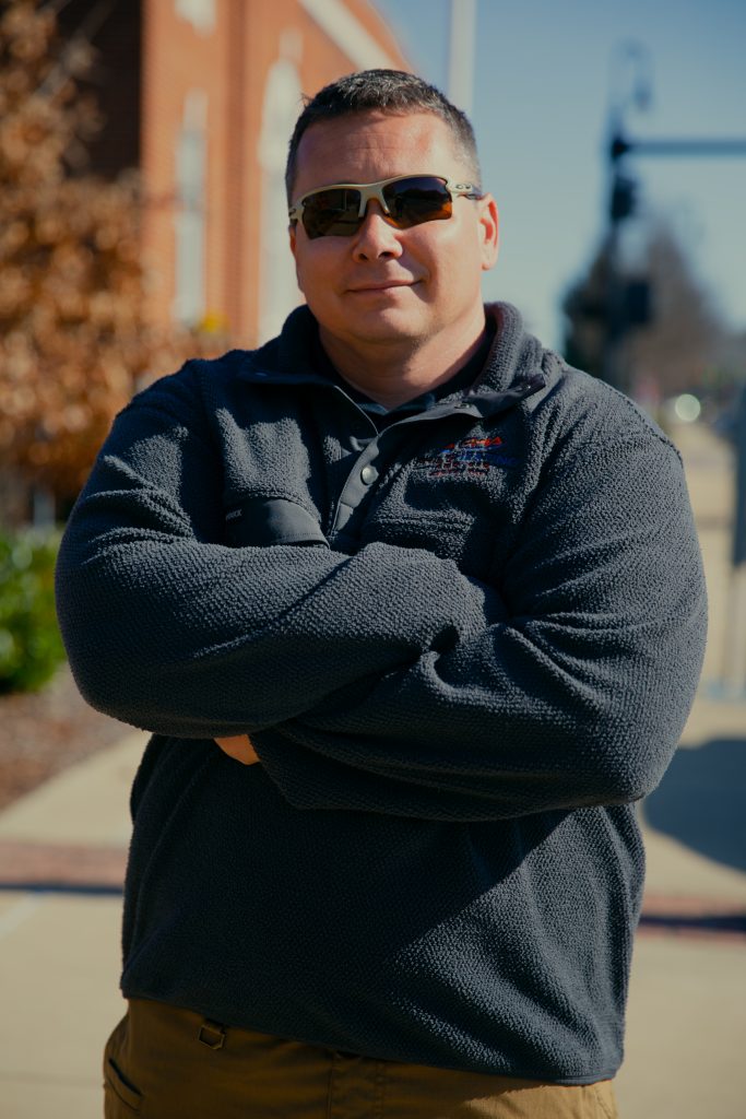 Contractor in sunglasses, smiling at the camera.