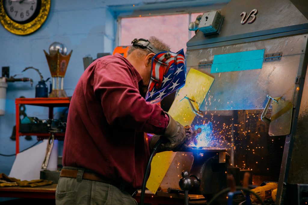 Artist welding in his studio.
