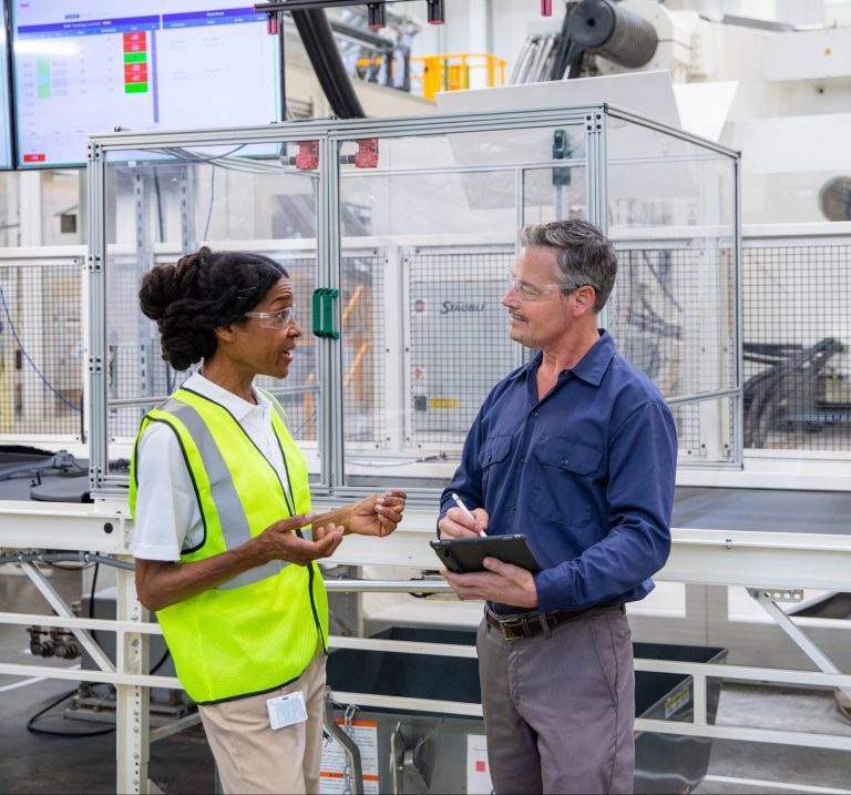 Contractor talking to business worker inside next to machinery