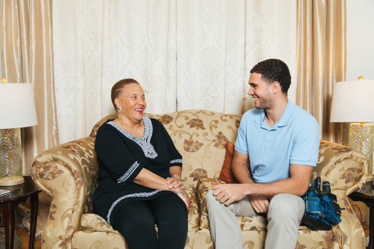 Contractor and homeowner sitting on couch and smiling at each other