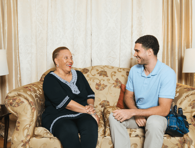 Contractor and homeowner sitting on couch and smiling at each other