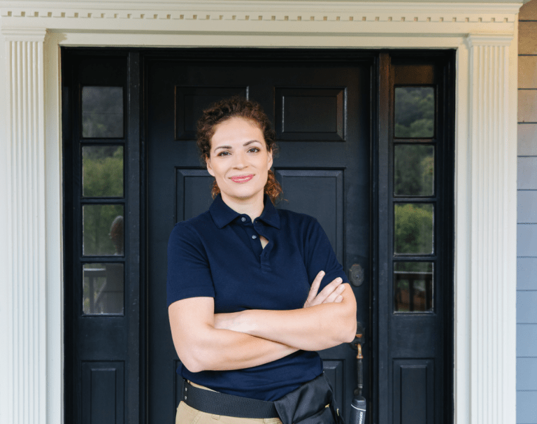 Contractor standing outside front door of house, smiling at camera