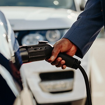 Close up of hand plugging in EV charger