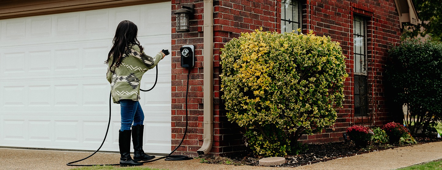 Woman putting up home EV charger