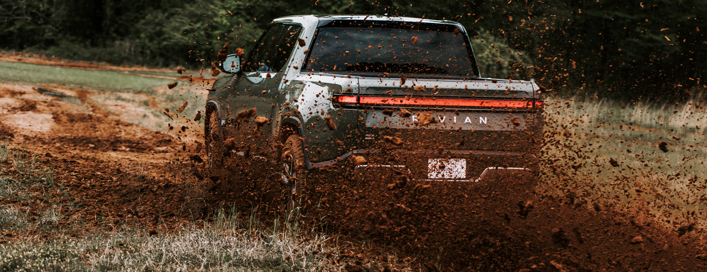 EV truck driving through mud