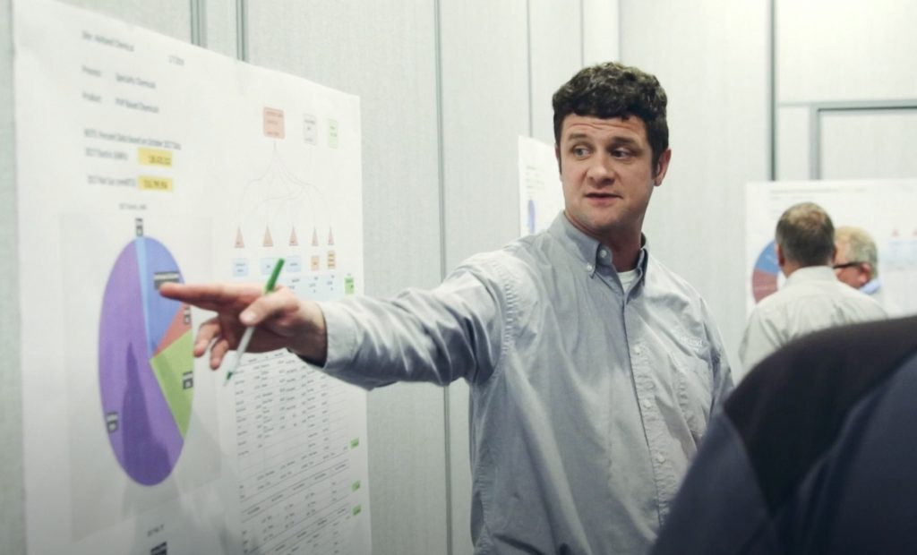 Man pointing at chart on the wall in office