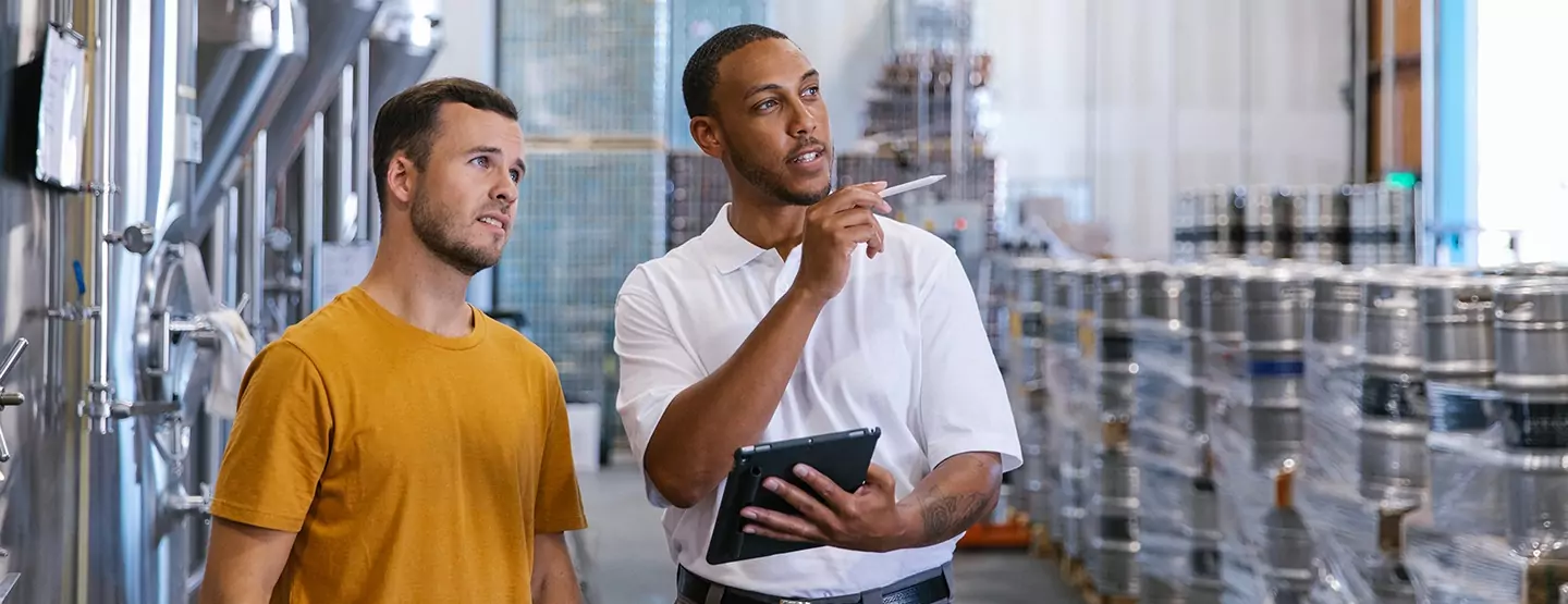 Two men in an industrial facility, pointing out energy saving opportunities.