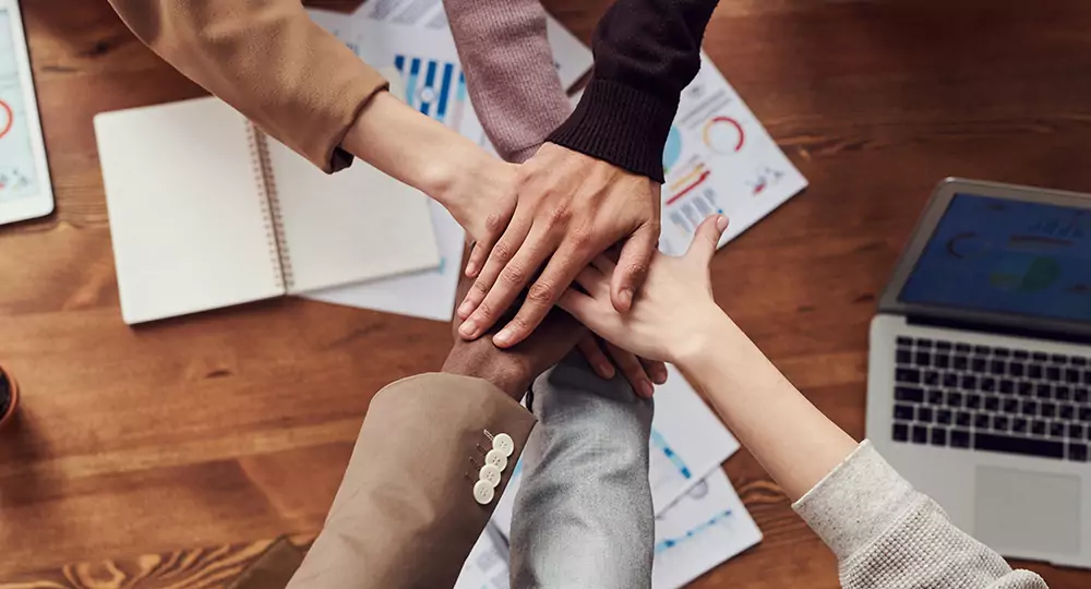 Hands joining to indicate teamwork and success.