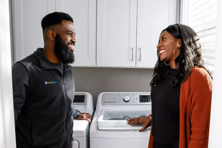TVA EnergyRight contractor standing in front of an energy efficient dryer with a homeowner.
