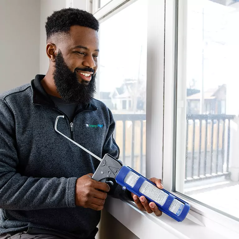 TVA EnergyRight Home Energy Advisor sealing a window with caulk.