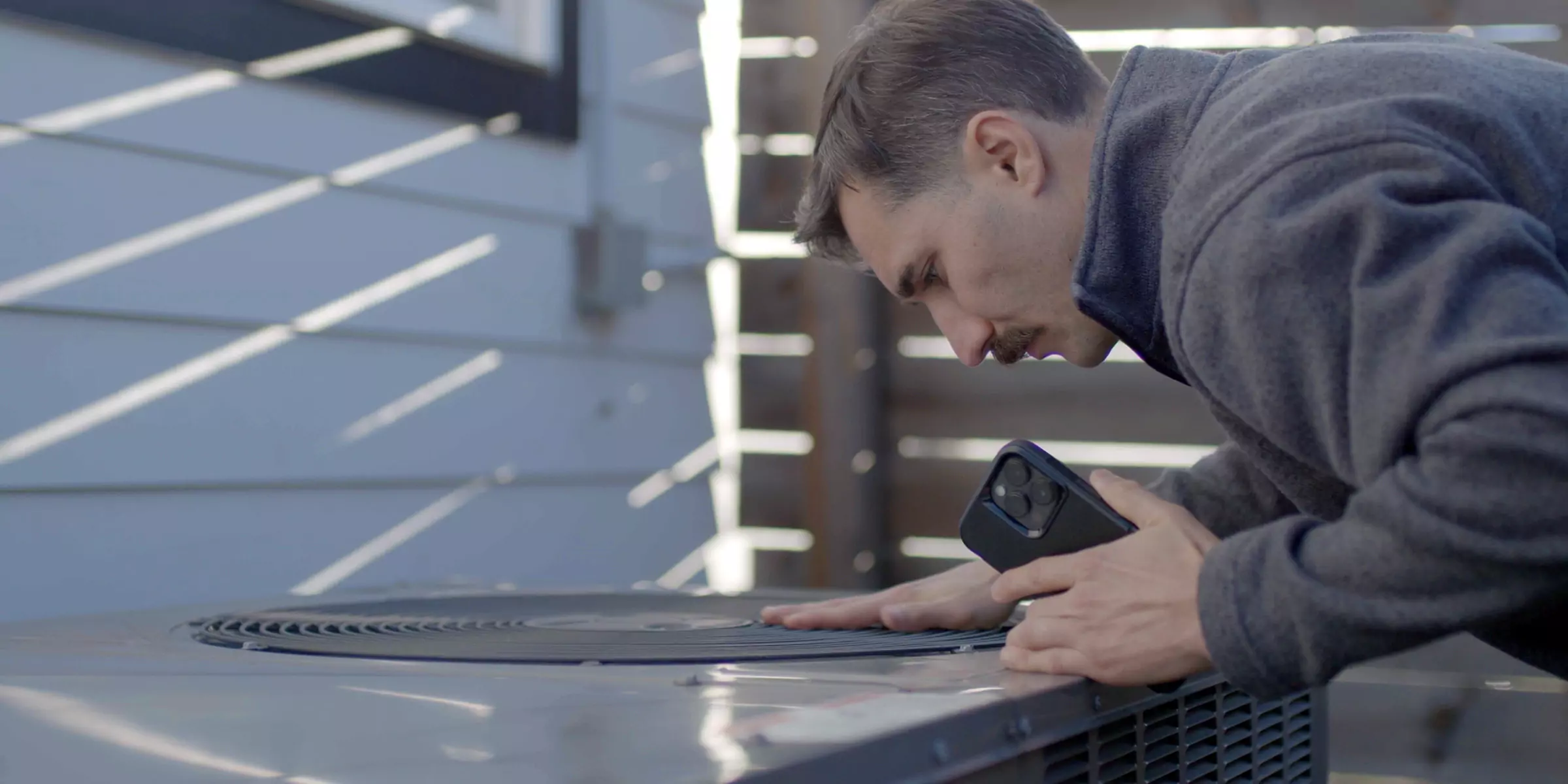 Man inspecting a traditional heat pump