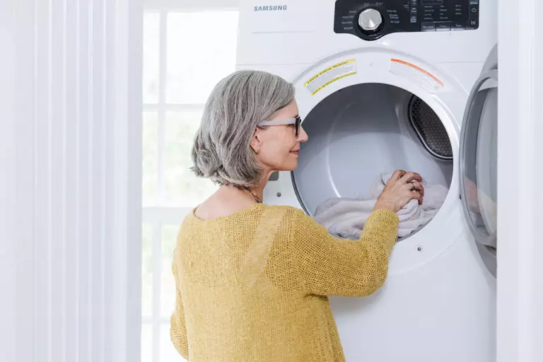 Woman taking towels out of an energy efficient dryer