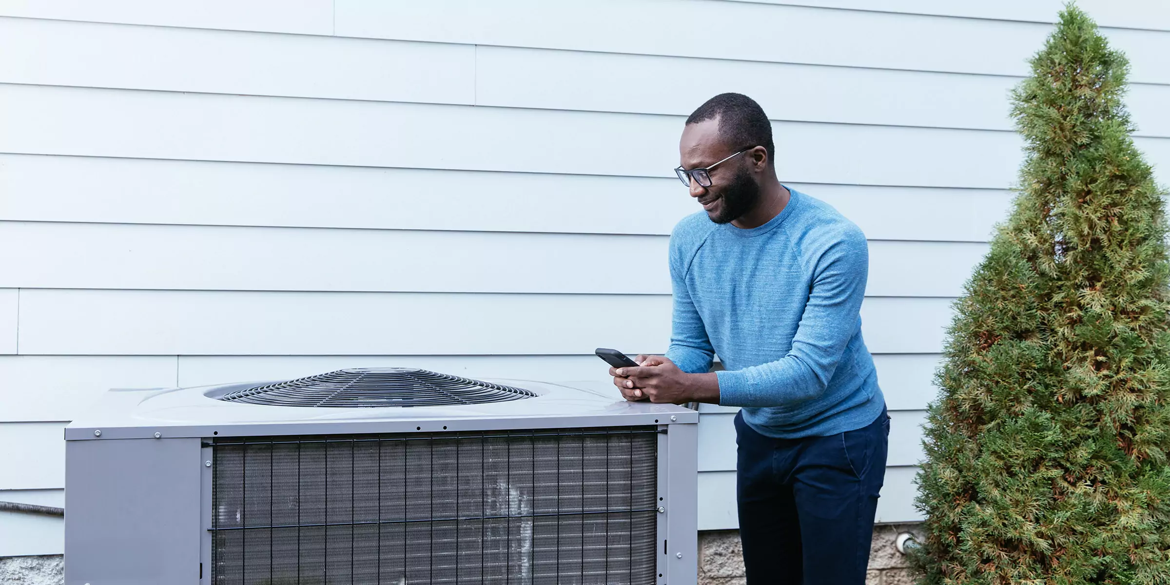Man inspecting external heat pump system.
