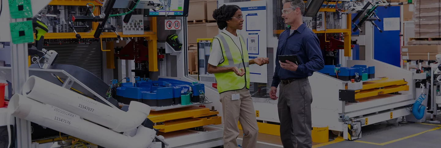 Energy advisor and plant operations person talking on plant floor.