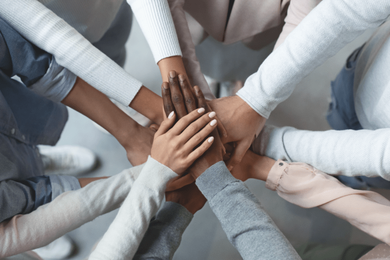 Many people putting their hands together