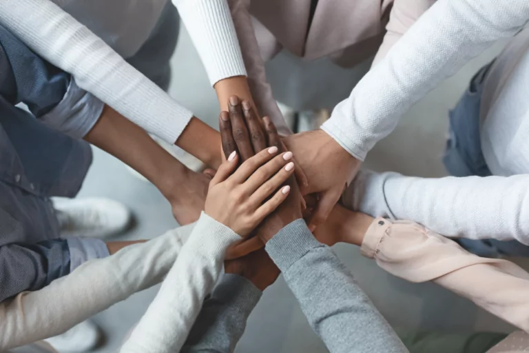 Many people putting their hands together