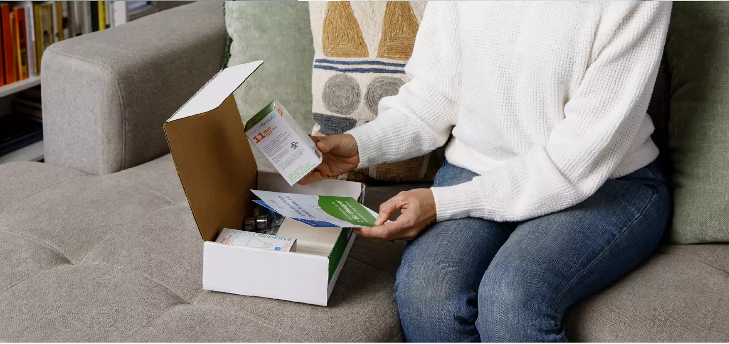 Homeowner opening a home energy-saving kit and reviewing instructions