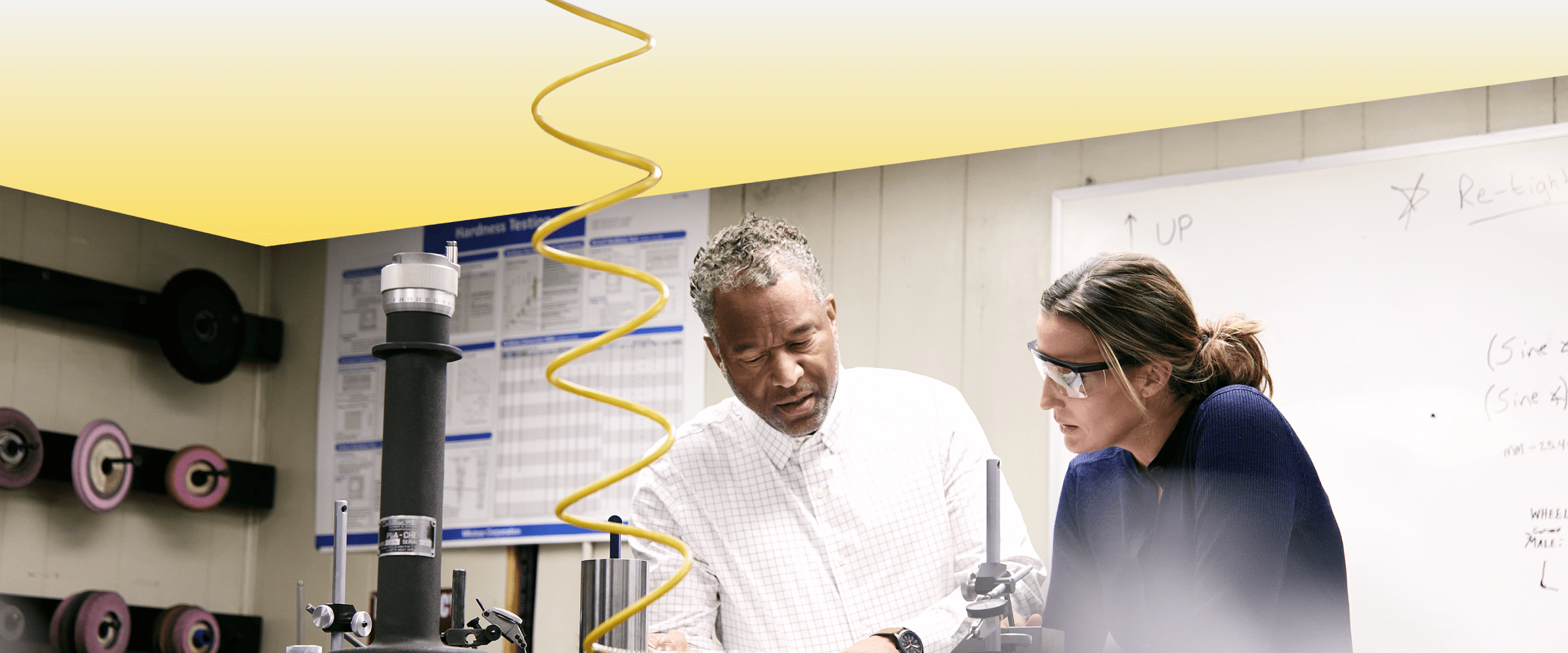 Two TVA Energy Experts collaborate while inspecting technical equipment inside an industrial laboratory testing facility.