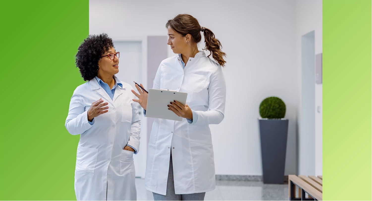 Two TVA Energy Experts in white coats collaborate on EnergyRight program strategies in a bright hallway.