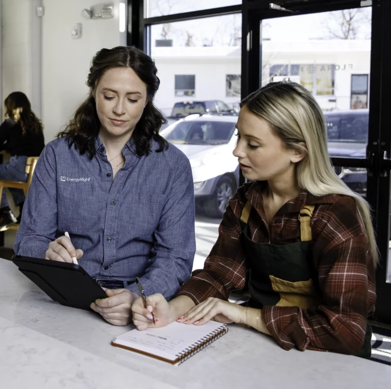 TVA Energy Expert uses a tablet to discuss commercial energy efficiency solutions and upgrades with a small business owner.