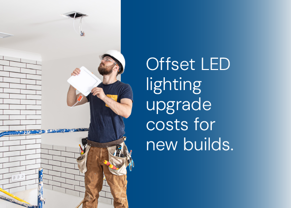 TVA Energy Expert installing an LED light panel, symbolizing energy-efficient LED upgrades and cost offsets for new builds.