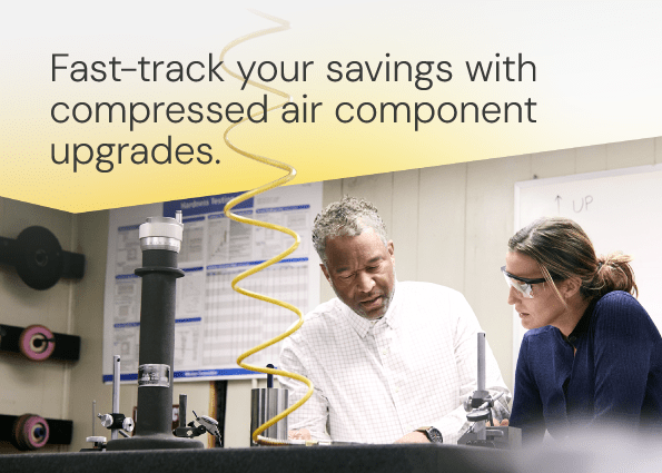 Two TVA Energy Experts, a man and a woman in safety glasses, collaborate on industrial equipment for compressed air upgrades.