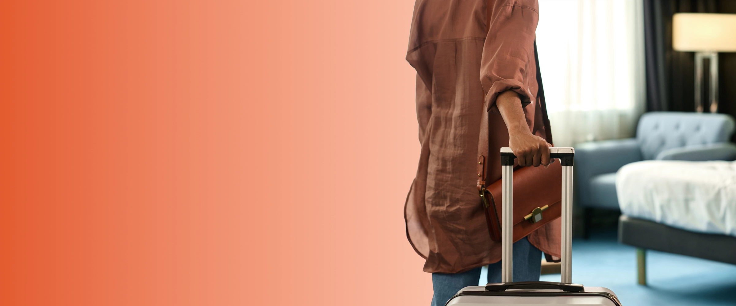 Person pulls suitcase into a bright hotel room, signaling opportunities for energy savings in commercial and hospitality settings.