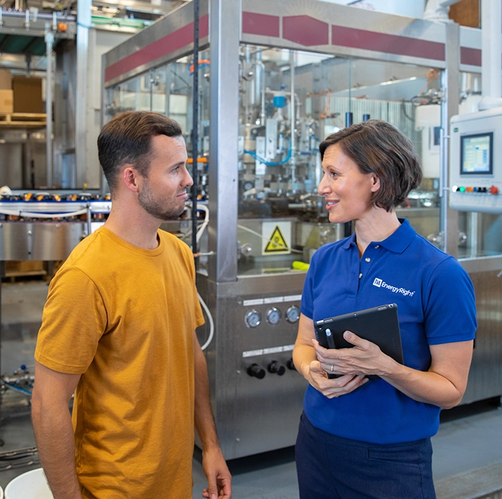 A TVA Energy Expert with a tablet consults a business operator on energy-saving initiatives in a commercial facility.