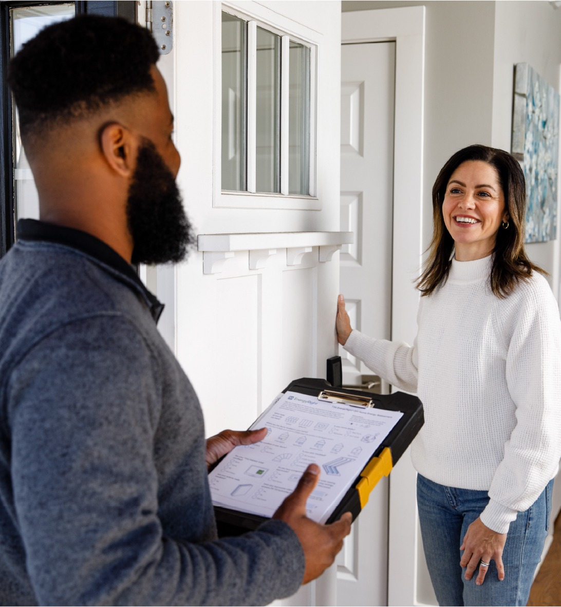 A TVA Energy Expert reviews an EnergyRight assessment with a smiling homeowner, discussing energy-saving solutions like heat pumps.