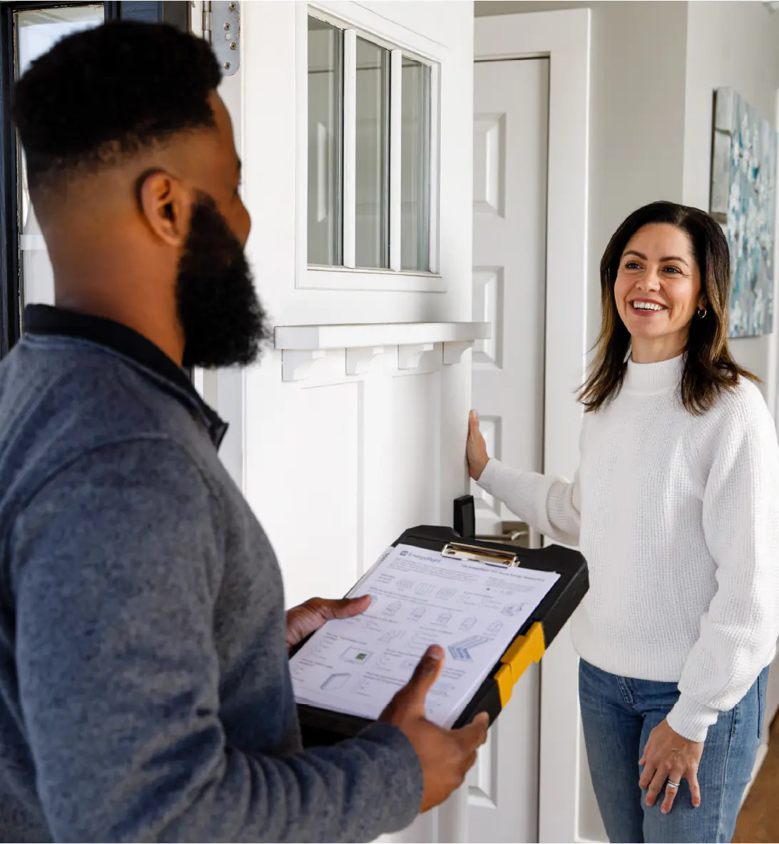 A TVA Energy Expert reviews an EnergyRight assessment with a smiling homeowner, discussing energy-saving solutions like heat pumps.