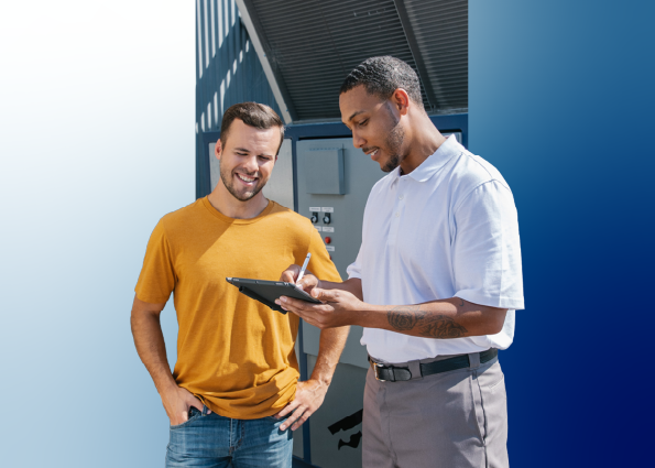 A TVA Energy Expert reviews energy savings on a tablet with a smiling customer, near an outdoor heat pump.